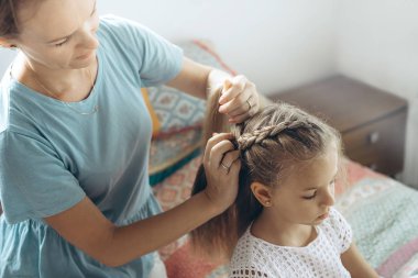 Anne ve kız, saç örgüsü.