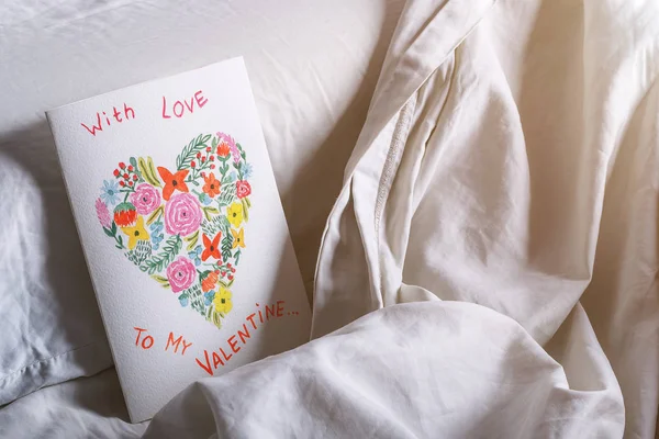 枕の上のベッドで水彩画でバレンタインデーハンドメイドの絵カード. — ストック写真