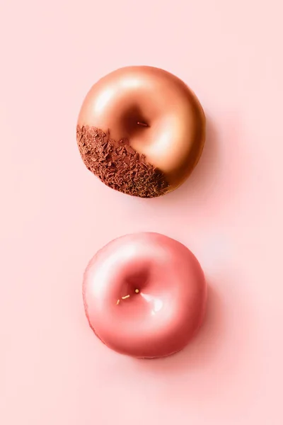 Fánk cukormázzal és csokoládéval pasztell rózsaszín háttérrel. Édes fánk — Stock Fotó