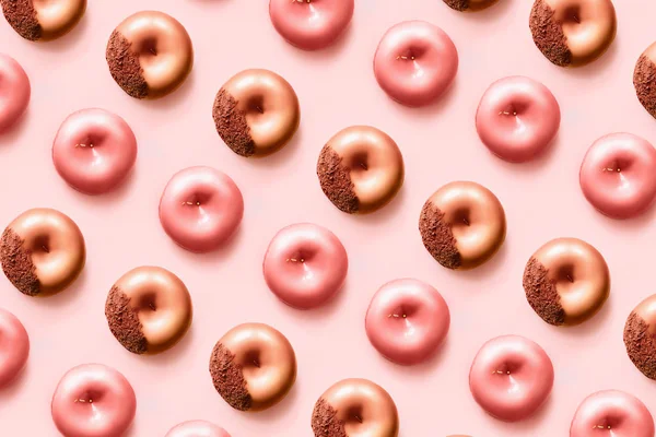 Patrón de d onuts con glaseado y chocolate sobre fondo rosa pastel. — Foto de Stock