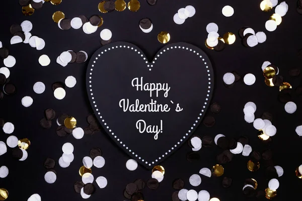 Confetti and black heart on the black background, Valentines Day, love — Stock Photo, Image
