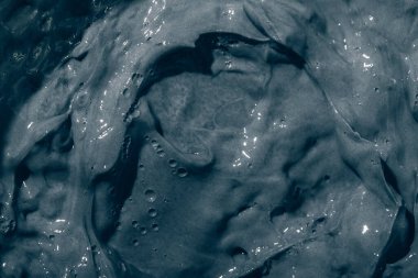 Yüzüne ve vücuduna siyah kilden maske kremi sürülmüş. Cilt bakımı kapatılıyor. Arkaplan