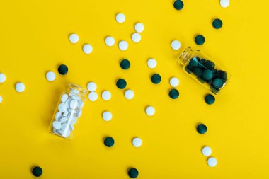 Sarı arkaplanda beyaz ve yeşil tabletler