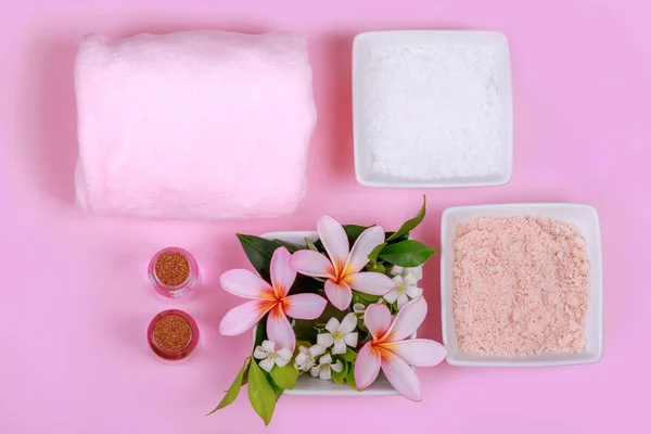 Wellness-Komposition mit Schalen mit felsweißem und rosa Salz und Blumen, Handtuch. Körperpeeling und Massage-Behandlung — Stockfoto