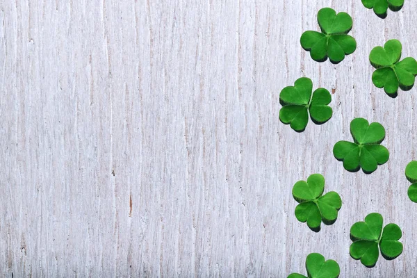 Patroon van shamrock bladeren op armoedige witte houten achtergrond met gratis kopieerruimte. St. Patricks Dag. — Stockfoto