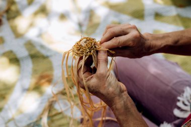 El işi atölyesinde kadın dokuma sepeti. El işçiliğini tutan eller, yakın çekim.