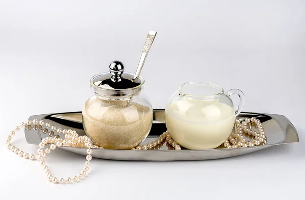 Tigela de açúcar e leiteiro em um prato de prata com pérolas isoladas no fundo branco — Fotografia de Stock