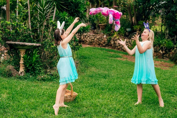 Cute little children wearing bunny ears on Easter day playing with Easter bunny toy — Stock Photo, Image