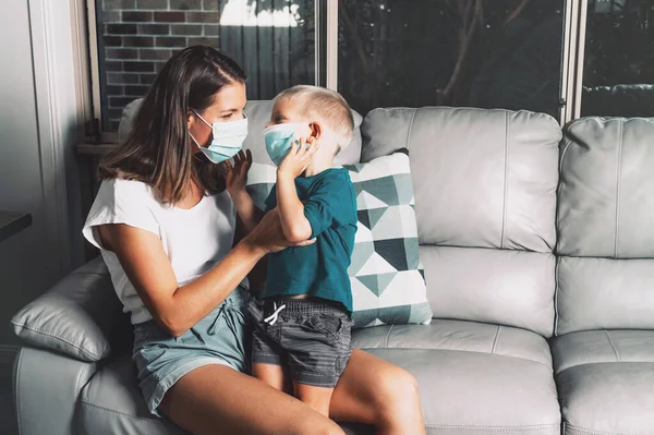 Mother and child wear facemask during coronavirus and flu outbreak staying at home. Virus protection. — Stock Photo, Image