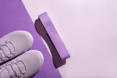 Yeni mor spor ayakkabılar ve renkli arka plan ile fotokopi alanı. Koşu ayakkabılarının yukarıdan çekimi.