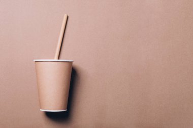 Kahve fincanı ve bambu bardağı doğal kağıtta pipet içiyor..