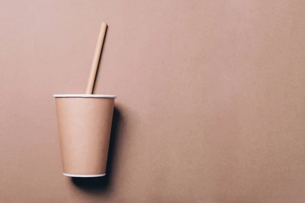 Taza de café para llevar con paja para beber de bambú sobre papel natural . — Foto de Stock