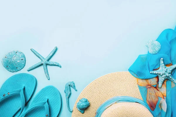 Moda de verano sobre fondo azul y coral. Chanclas azules, conchas marinas, gafas de sol, botella y sombrero de paja . — Foto de Stock