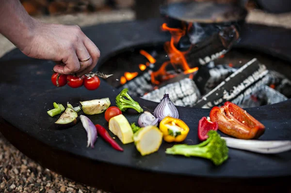 Mano mettendo pomodori alla griglia . — Foto Stock