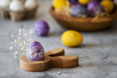 close-up photo of purple and yellow Easter eggs on concreted table with blurred background  clipart