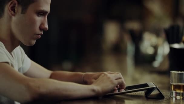 Ο άνθρωπος χρησιμοποιώντας tablet σε ένα μπαρ ο μετρητής — Αρχείο Βίντεο