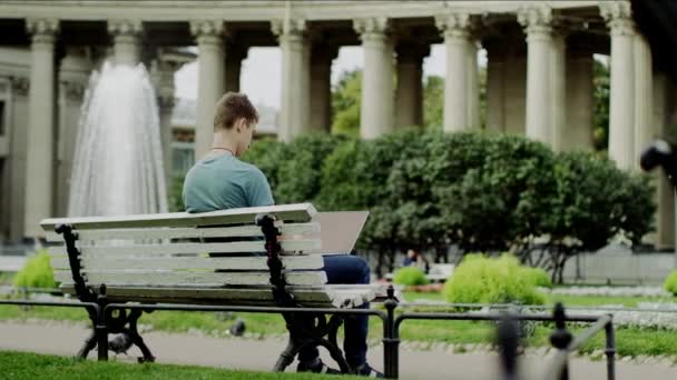 Людина з ноутбуком на лавці — стокове відео