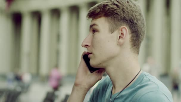 Человек разговаривает по мобильному телефону на улице — стоковое видео