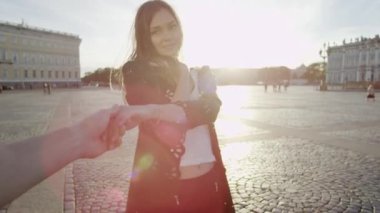 Poz ve fotoğrafçı elini tutarak güzel genç kadın