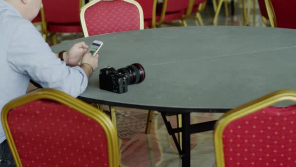 Homme assis à la table en utilisant iphone — Video