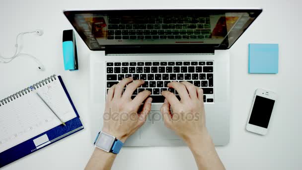 Een man typt op een laptop op zijn Bureau — Stockvideo