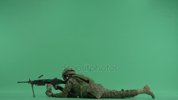 Soldado acostado y apuntando a la izquierda en la pantalla verde — Vídeo de stock