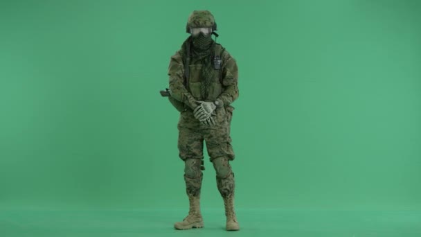 Soldier standing and targeting around at green screen — Stock Video