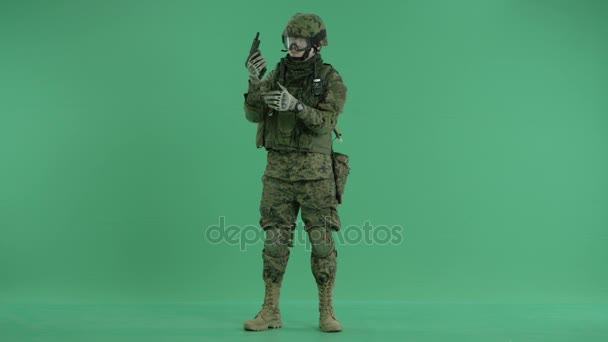 Combatiente sosteniendo un arma en el fondo de la pantalla verde — Vídeos de Stock
