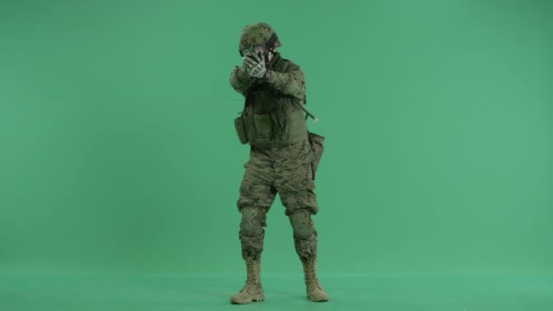 Soldado de pie y apuntando alrededor con pistola en la pantalla verde — Vídeos de Stock