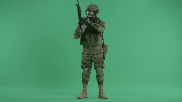 Soldier standing and targeting around at green screen — Stock Video