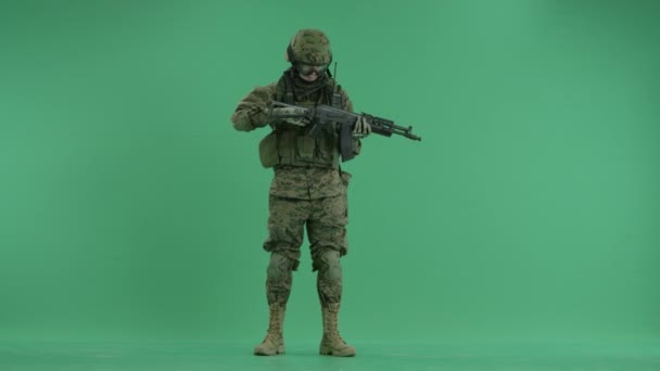 Serviceman de pé com arma e recarregá-lo na tela verde — Vídeo de Stock