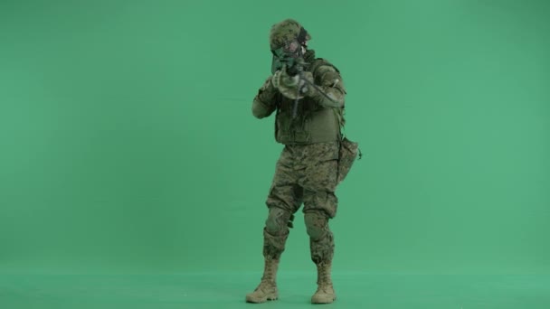 Serviceman standing and targeting around at green screen — Stock Video