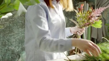 gülümseyen kadın çiçekçi buket çiçek dükkanında düzenlenmesi