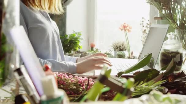 Vista lateral de sorrir florista digitação no laptop — Vídeo de Stock