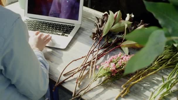 Ovanifrån av florist arbetar med laptop — Stockvideo