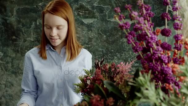Gember bloemist schikken van exotische bloemen in bouqet — Stockvideo