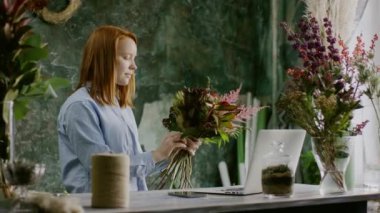 Çiçekçi Çiçek bilgisayarın yakınında demet bağlama