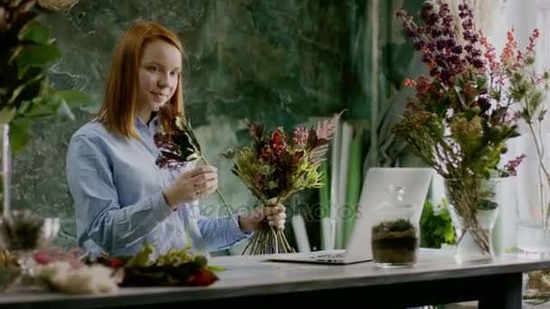 Niedliche Blumenhändlerin arrangiert Blumenstrauß — Stockvideo