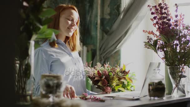 Zijaanzicht van het glimlachen bloemist arrangingf bloemen — Stockvideo