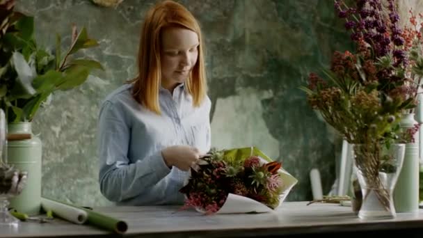 Bloemist het samenstellen van een regeling van bloemen — Stockvideo