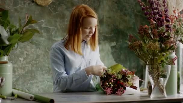 Усміхнений Флорист збирає композицію з квітів — стокове відео