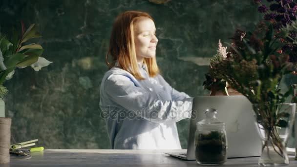 Florista sorrindo mostrando monte de flores no skype — Vídeo de Stock