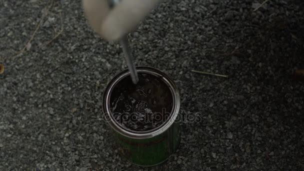 Mans hand is stirring colour in tin — Stock Video