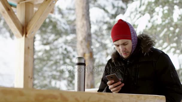 Hombre llamando por un teléfono en invierno al aire libre — Vídeo de stock