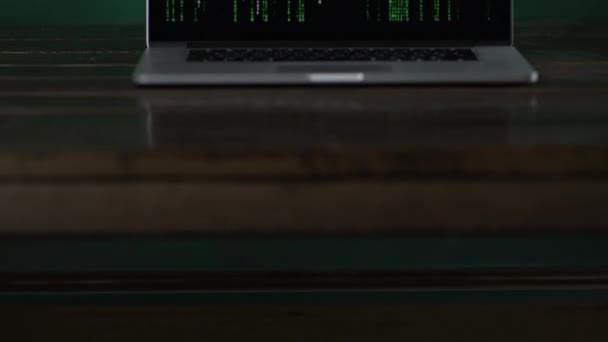 View of a laptop standing at the desk with vertical binary code — Stock Video