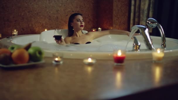Mujer bebiendo vino tinto en baño con espuma — Vídeos de Stock