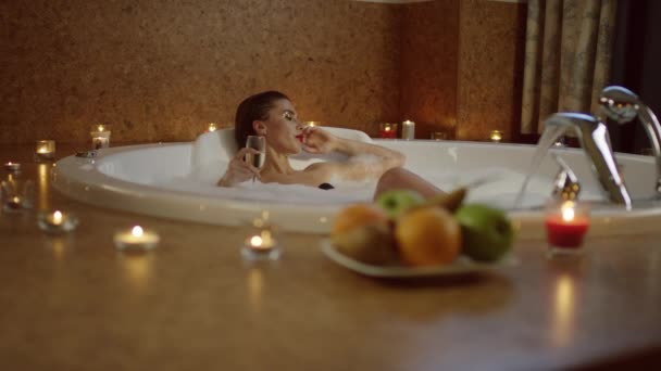 Woman with glass of champagne in bath with foam — Stock Video