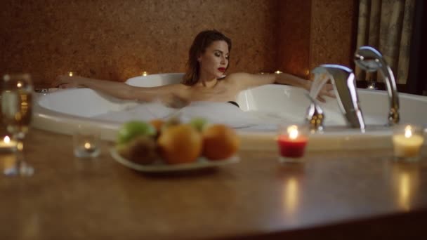 年轻女子躺在按摩浴缸，泡沫 — 图库视频影像