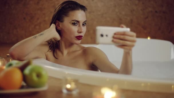 Frau posiert vor Frontkamera in Badewanne mit Schaum — Stockvideo