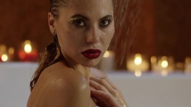 güzel kadının görünümü parlak kozmetik banyo kameraya bakarak ile yakın.